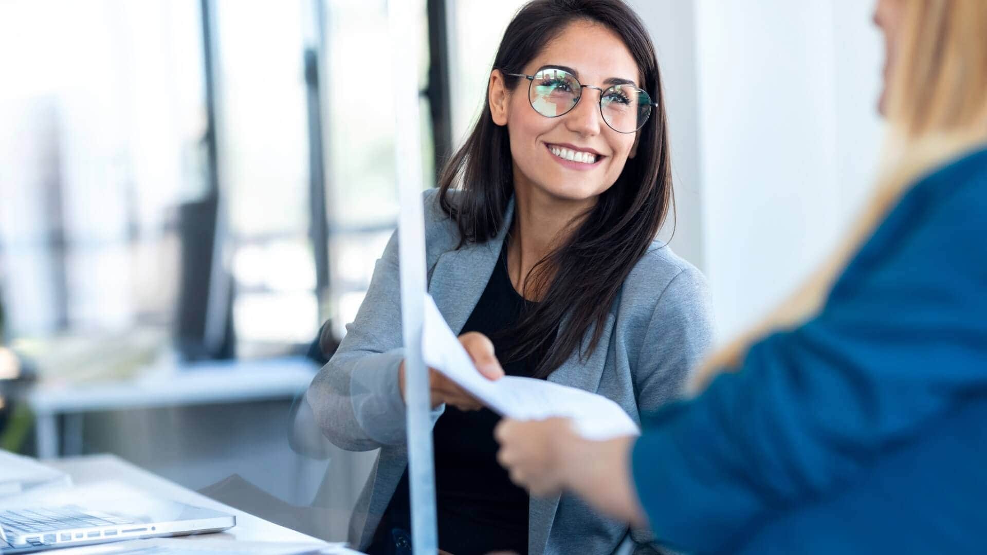 Mujer entregando un documento en oficina